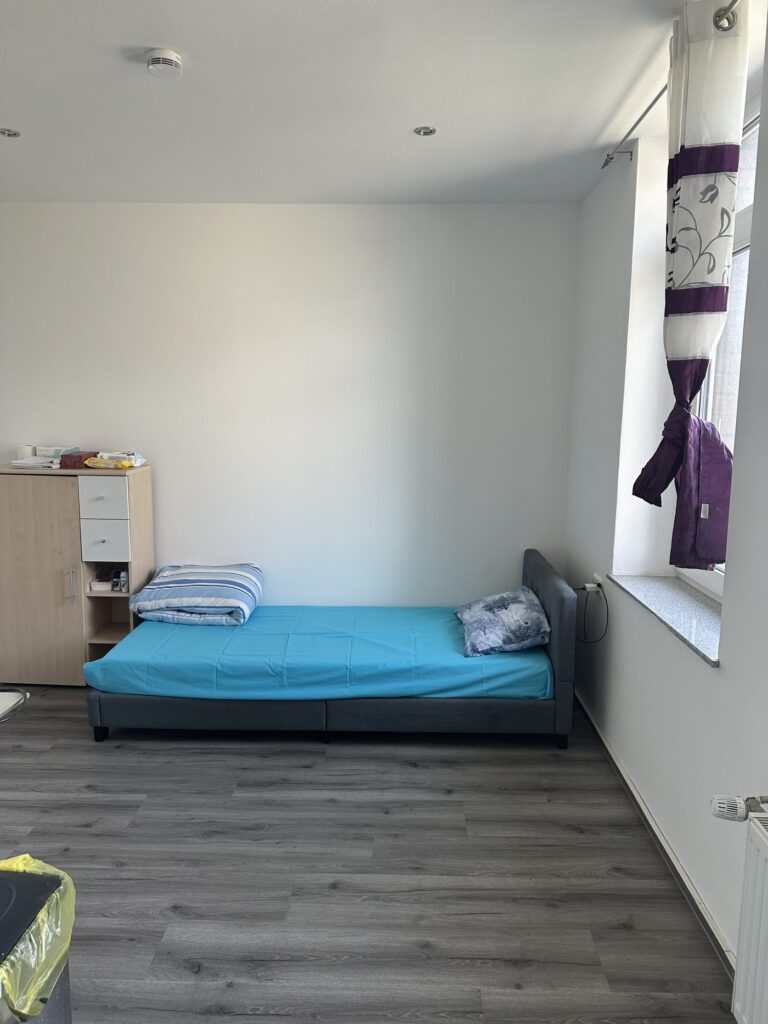 Einzelzimmer mit Bett und Kommode im Hotel Heidekamp Bielefeld