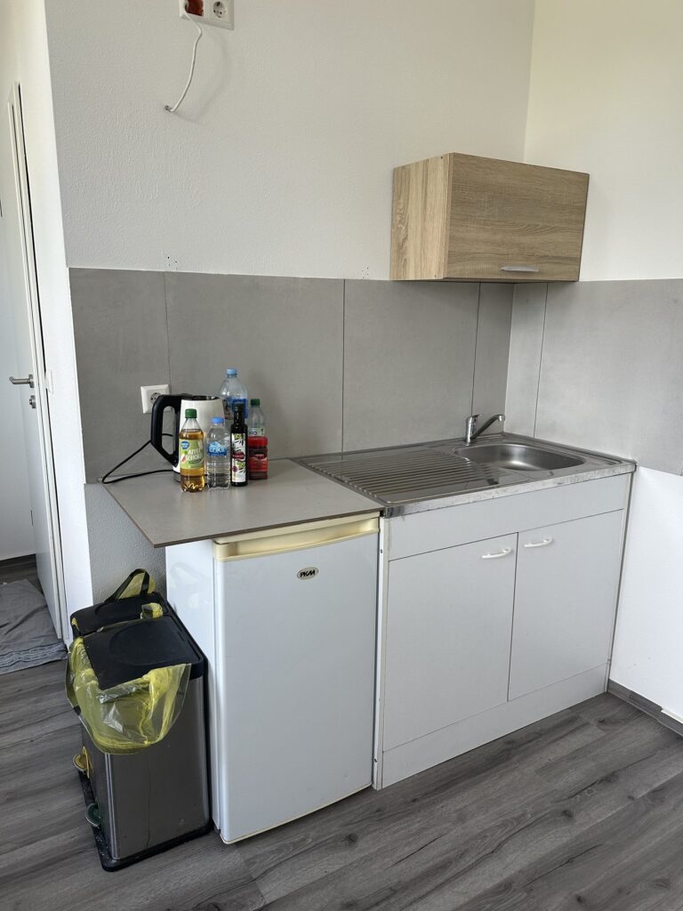 Singleküche mit Kühlschrank, Spüle und Kochfeld im Hotel Heidekamp Bielefeld