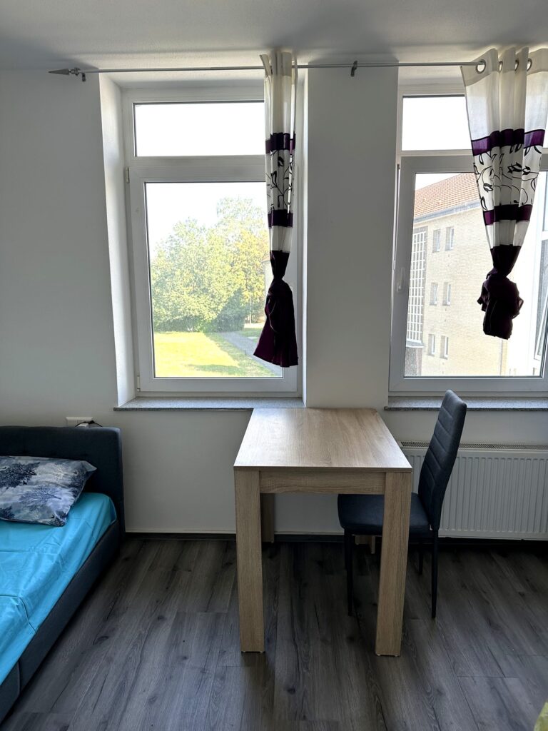 Zimmer mit Bett, Schreibtisch und Stuhl im Hotel Heidekamp Bielefeld